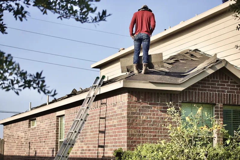 Professional roofer working on a residential roof in Plainview